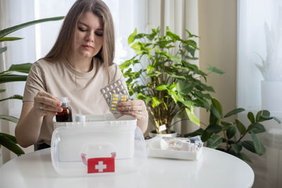 Young woman sitting on table at home