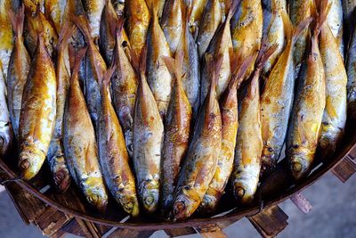 Grilled fishes in bowl at market for sale