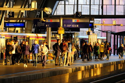 Group of people walking on railroad station platform