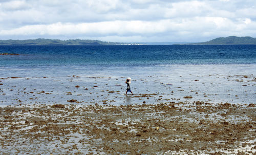 Man standing on beach against sky