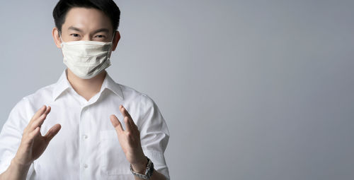 Portrait of young man standing against white background