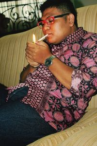 Young man sitting on sofa at home