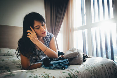 Young woman lying on bed at home