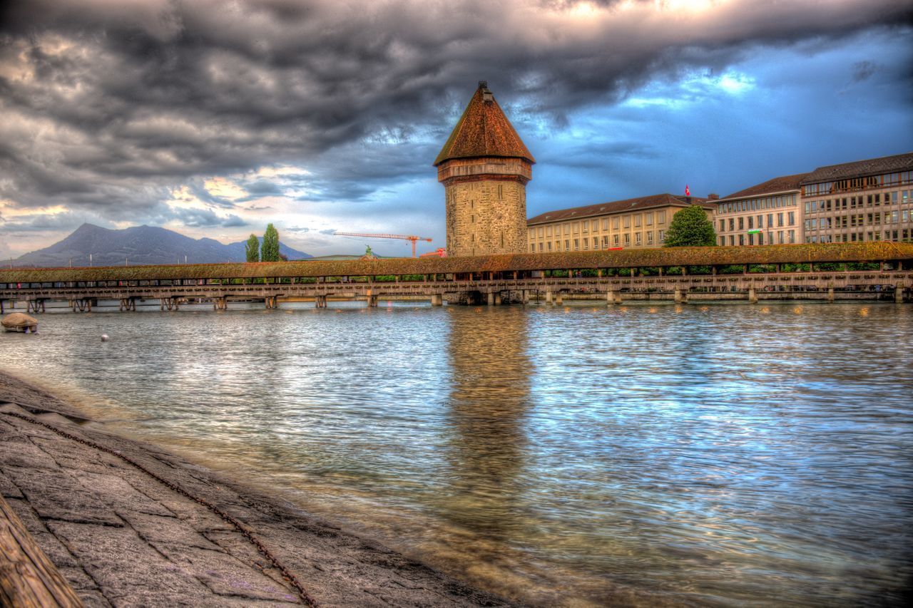 BRIDGE OVER RIVER AGAINST BUILDINGS AND SKY