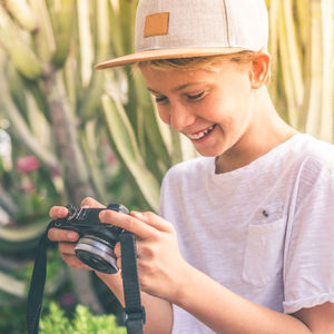 Portrait of smiling young man holding hat