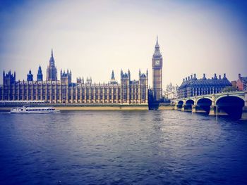 View of tower bridge over river in city against sky