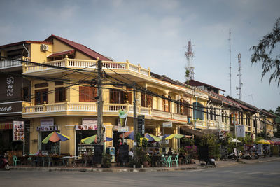 Buildings by road against sky in city