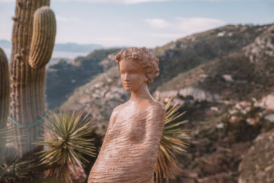 Young woman standing by tree on mountain