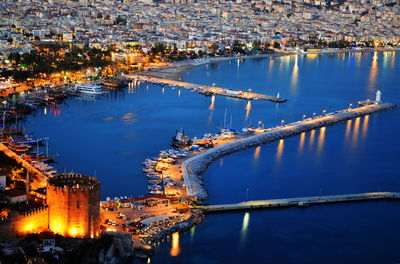 High angle view of illuminated buildings by river at night