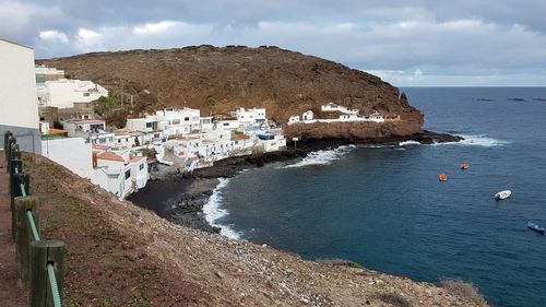 Townscape by sea against sky in town