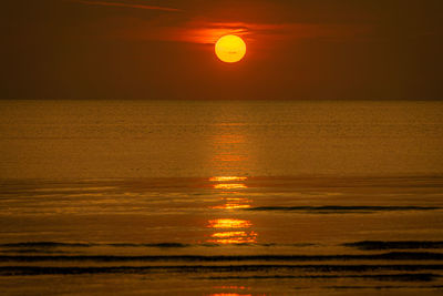 Scenic view of sea against orange sky