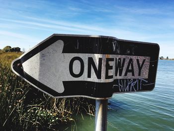 Close-up of road sign against sky