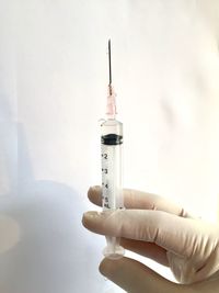 Close-up of hand holding syringe