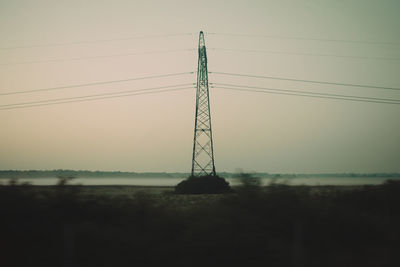 Electricity pylon against sky during sunset