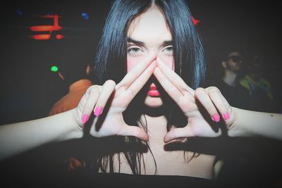 Portrait of beautiful woman gesturing while standing at nightclub