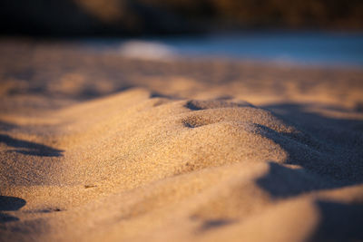Close-up of sand at beach against sky