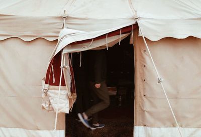 Low section of woman standing against the tent