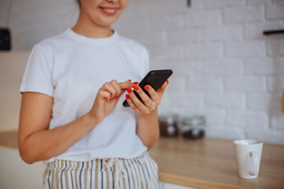 Midsection of woman using mobile phone