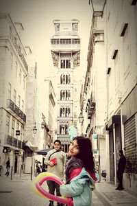 People on street amidst buildings in city