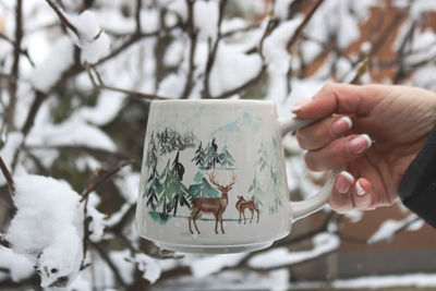 Close-up of hand holding coffee cup