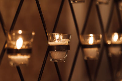 Close-up of illuminated candles on glass