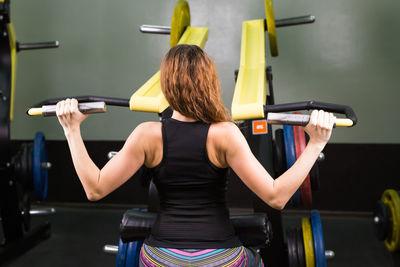 Rear view of woman with arms raised