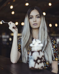Portrait of beautiful young woman with dessert in foreground