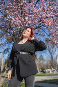 Young woman standing against trees