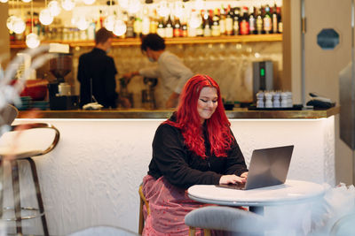 Woman sitting on table in restaurant