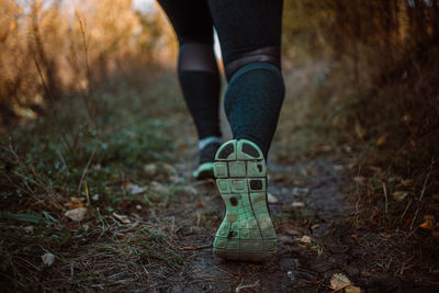 Low section of woman standing on field