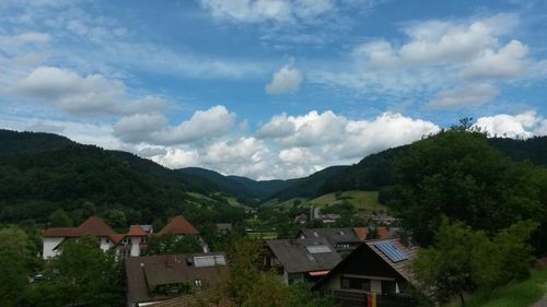 Houses by mountains against sky