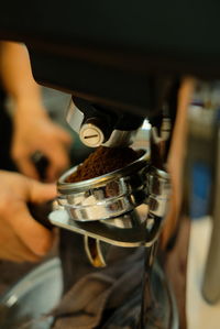Close-up of hand using coffee machine