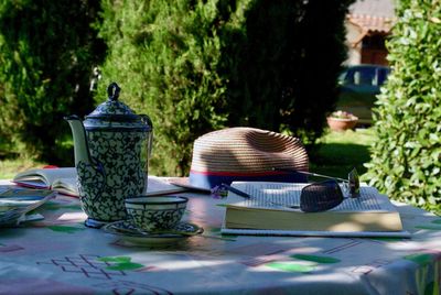 Lantern on table against plants in yard