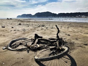 Bicycle on beach against sky