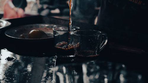 Someone pouring tea on a tea cup