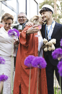 Smiling men and women enjoying during back yard summer party