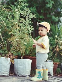 Portrait of young woman holding potted plant