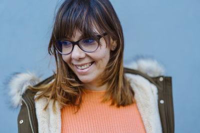 Smiling young woman against wall