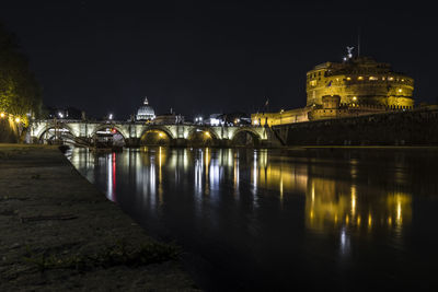 Illuminated bridge over river at night