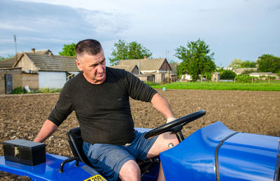 Kherson oblast, ukraine - may 29, 2021. an elderly farmer sits and drives a tractor. 