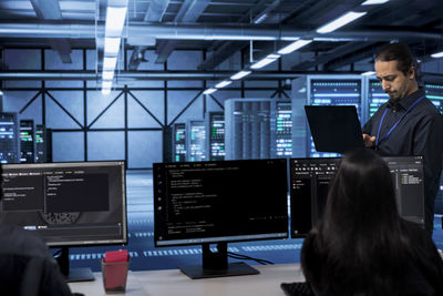 Rear view of businessman using laptop in office
