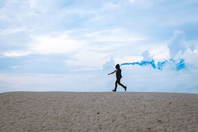 Full length of man standing on beach against sky