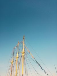 Low angle view of sailboat against clear blue sky