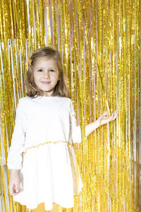 Portrait of cute girl standing by tinsel