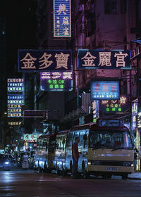 Illuminated sign on street in city at night