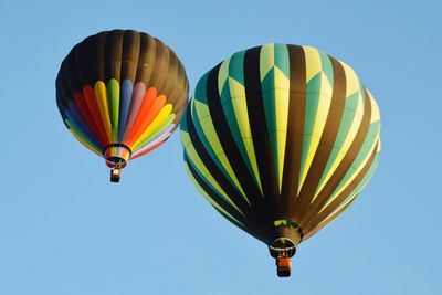 Low angle view of hot air balloons against blue sky