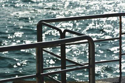 Close-up of metal railing by swimming pool against sky