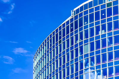 Low angle view of modern building against blue sky