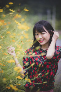 Portrait of smiling young woman standing on land