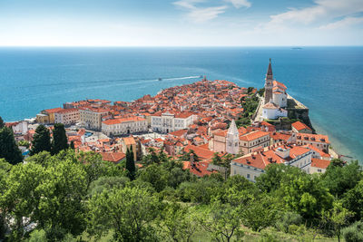 High angle view of townscape by sea against sky